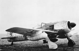Imagine atasata: Focke-Wulf-Fw-190G-carring-a-1200-lb-bomb-and-long-range-underwing-fuel-tanks-IWM-CH-16121.jpg